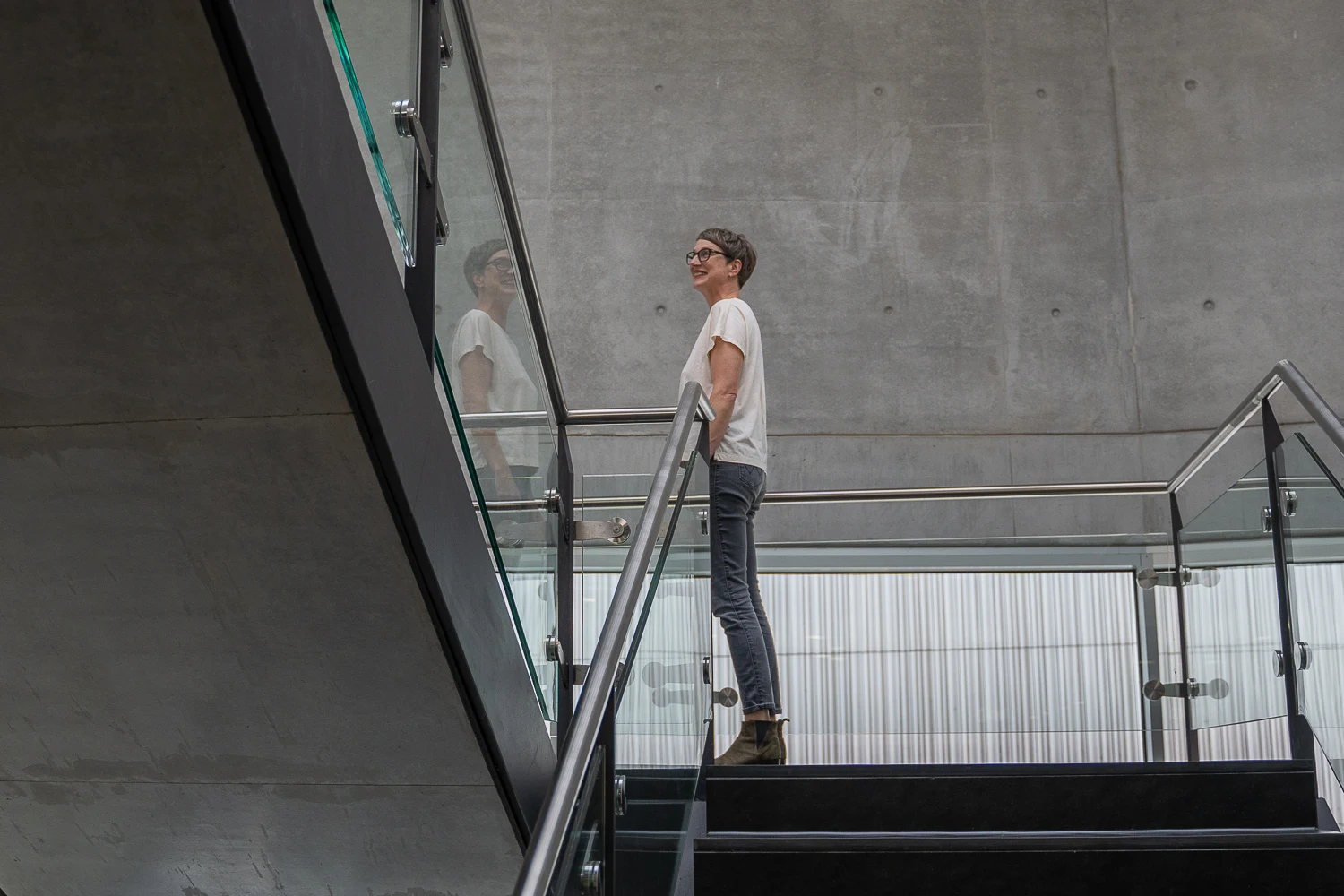 Katja Koehler auf einer Treppe in einer offenen, modernen Architektur